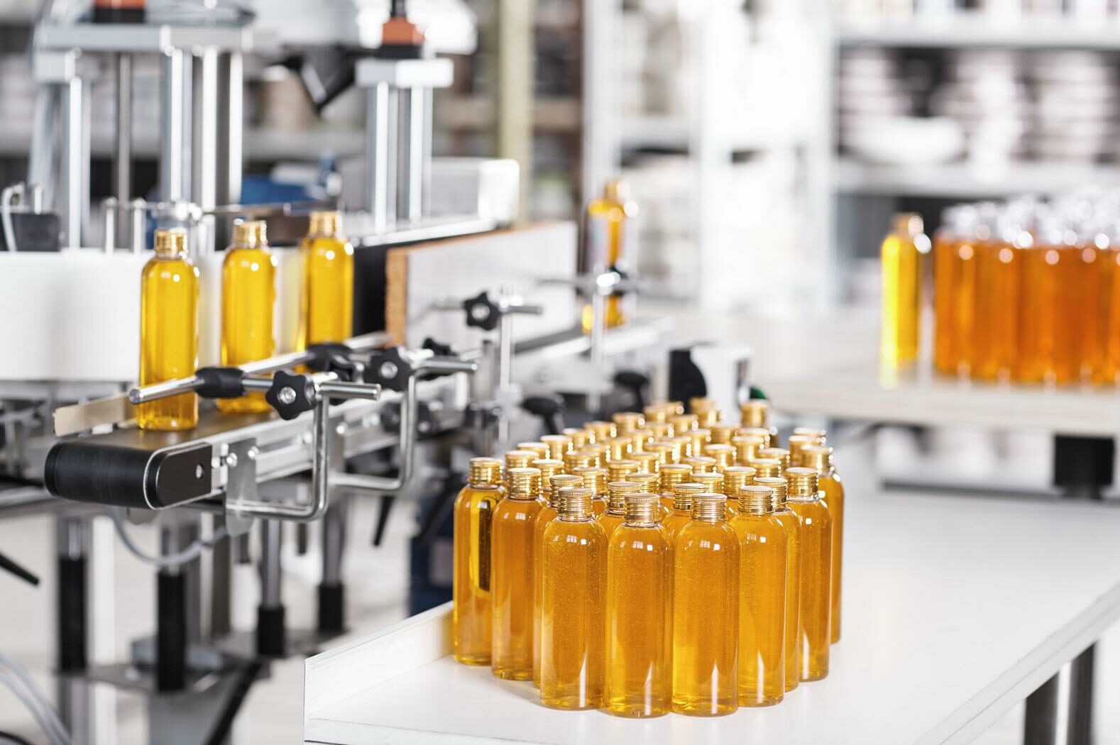 Cosmetics factory. Bottling line filled with yellow shampoo. Aut